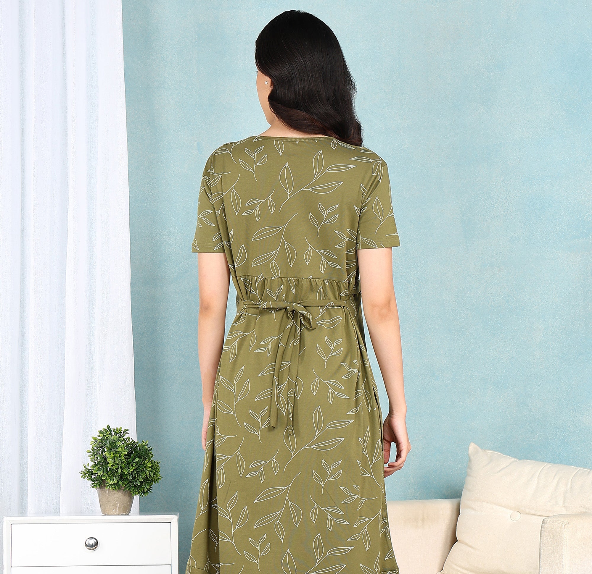 Woman wearing a green matrnity dress with a pattern